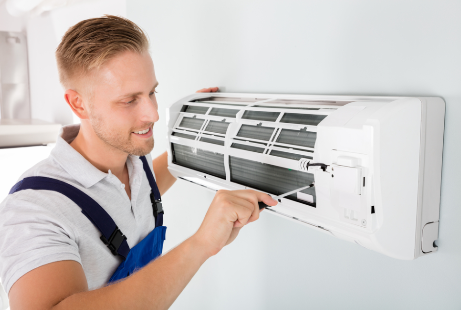 smiling service man fixing aircon